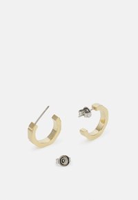 Orecchini a cerchio geometrici in oro con una finitura spazzolata. Include un perno posteriore in argento. La forma esagonale unica esalta i dettagli del design.