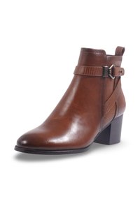 Bottine en cuir marron avec un bout pointu, un panneau latéral texturé et une sangle décorative avec une boucle en métal. Talon empilé.