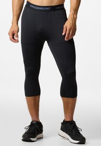Black athletic capri pants made of stretchy fabric, featuring a branded waistband and a form-fitting design, cut just below the knee.