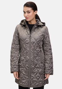 Kurtka pikowana z kapturem w kolorze taupe, z przednim zamkiem błyskawicznym, bocznymi kieszeniami i teksturowanym wzorem. Wykonana z lekkiego materiału syntetycznego.