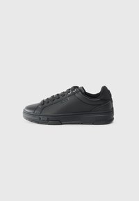 Black athletic sneakers with a smooth leather upper, rounded toe, lace-up front, and textured rubber sole; logo detail on the heel.