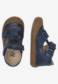 Námořnické modré kožené sandály s dvěma nastavitelnými popruhy, hnědými gumovými podrážkami a výřezy na stranách. Hladký povrch a zaoblený tvar.