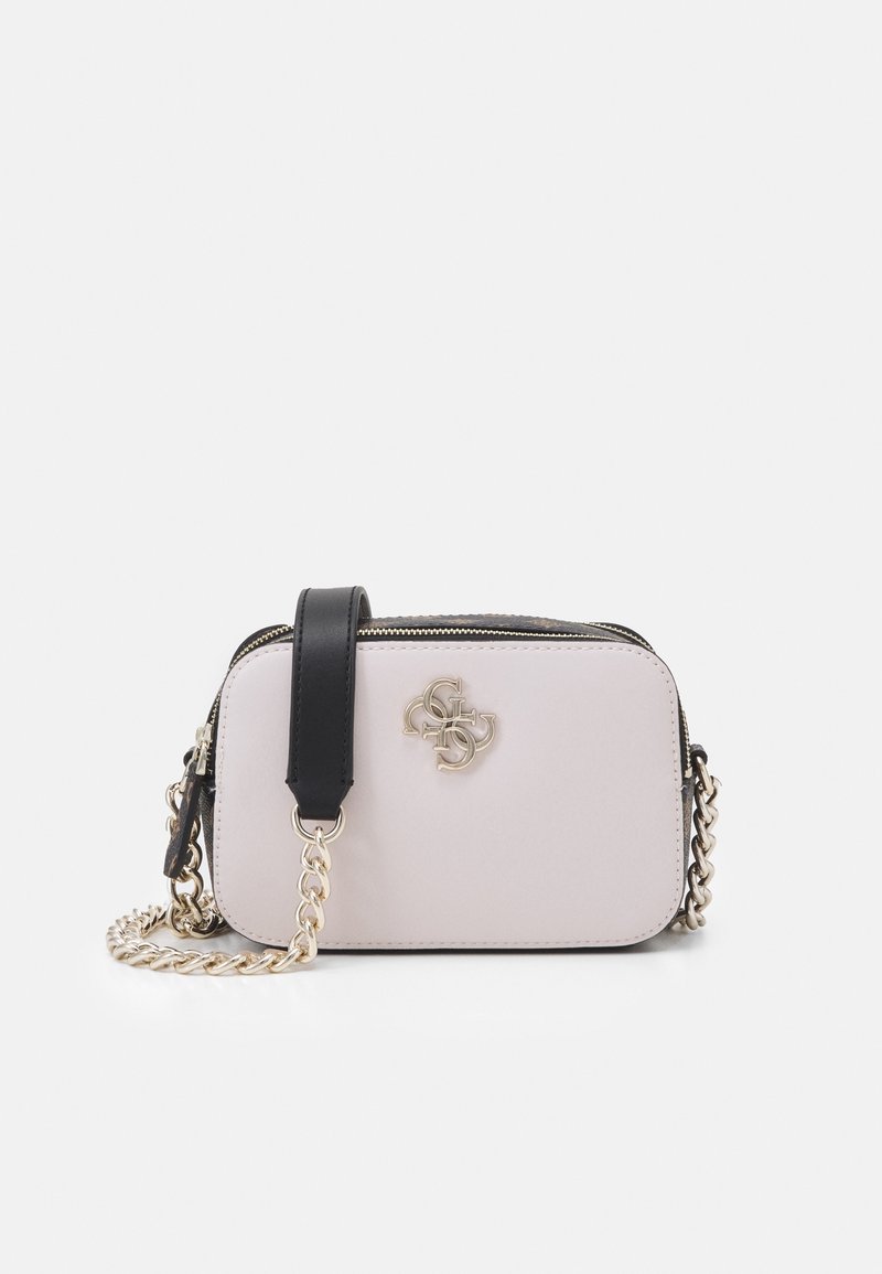 Compact crossbody bag in light pink with black accents, smooth texture, silver chain strap, and a logo detail on the front. Zipper closure.