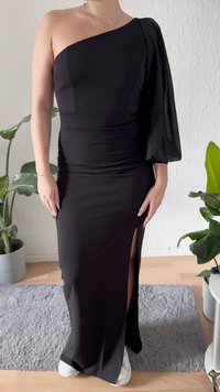 Vestido preto de um ombro só com um design justo e fenda lateral. Feito de tecido suave, apresenta uma manga realçada e uma silhueta longa.