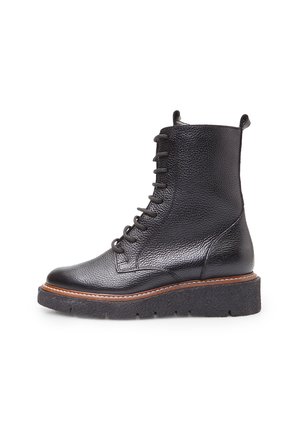 Black leather hiking boots with a round toe, textured upper, thick platform sole, and lace-up front with pull tab at the heel.