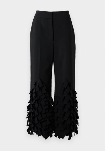 Pantalones anchos negros con cintura alta, que presentan un diseño de volantes texturizados en el dobladillo, hechos de piezas de tejido en capas.