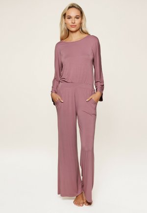Langdurige jumpsuit in gedempt mauve, gemaakt van zachte stof. Heeft een relaxte pasvorm, zijzakken en wijde broekspijpen.