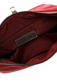 Rotes Stofftäschchen mit schwarzem Reißverschluss, Innenreißverschlusstasche und einem dunkel Lederetikett mit der Aufschrift "EMILY & NOAH".