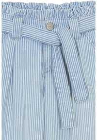 Tissu rayé bleu clair et blanc avec une taille volante, une ceinture nouée et un détail de bouton en métal ressemblant à un pantalon ou un short décontracté.