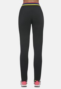 Czarne legginsy z wysokim stanem, ozdobione wielokolorowymi paskami w odcieniach czerwieni, żółci i błękitu. Gładka tekstura, dopasowany krój.