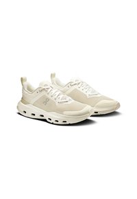 Sneakers atletiche leggere in mesh e materiali sintetici, dotati di una suola imbottita con fori e dettagli texturizzati.