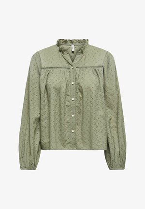 Blouse à manches longues vert clair avec broderie ajourée, col à volants, boutons-pression sur le devant et poignets élastiqués sur les manches.
