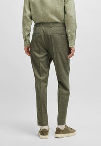 Olijfgroene op maat gemaakte broeken van textuurstof met een slim fit, voorzien van achterzakken en gecombineerd met lichte sneakers.
