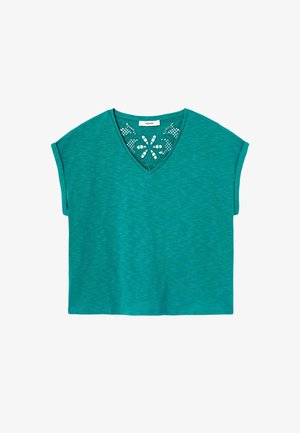 Haut à manches courtes couleur sarcelle avec encolure en V et motif en dentelle florale décorative à l'intérieur de l'encolure.