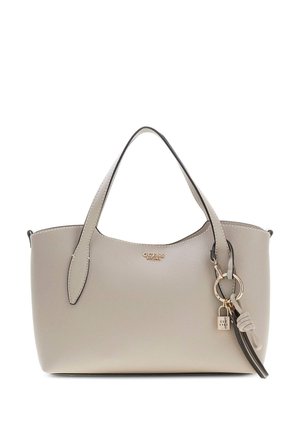 Sac à main en cuir beige clair avec deux poignées, logo Guess doré et porte-clés décoratif avec cadenas doré et pampille sur le côté.