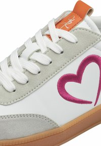 Weiße Ledersneaker mit grauen Wildlederspitzen, ausgestattet mit einem pinken gestickten Herzdesign, orangefarbenem Fersenpatch und weißen Schnürsenkeln. Gummi-Gummisohle.