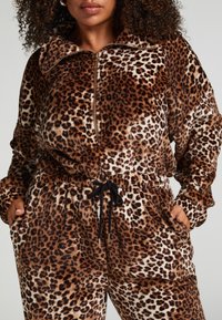 Lāču raksta flīsa mājas apģērbs, ar augstu apkakli, rāvējslēdzēju un elastīgu jostu ar auklu. Strukturēts, mīksts audums.