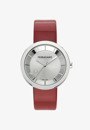Ferragamo kellaga, millel on hõbedane roostevabast terasest ümar kellapea, punane läikiv nahkrihm, tekstureeritud kellapind ja julged tunniindikaatorid. Omab Šveitsi valmistatud brändimist.