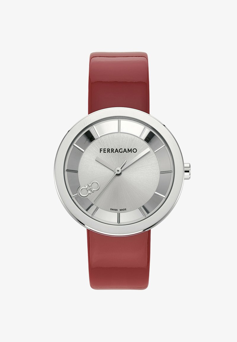 Ferragamo kellaga, millel on hõbedane roostevabast terasest ümar kellapea, punane läikiv nahkrihm, tekstureeritud kellapind ja julged tunniindikaatorid. Omab Šveitsi valmistatud brändimist.