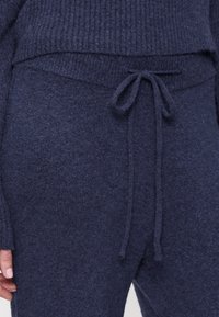 Granatowe dzianinowe spodnie do wypoczynku z paskiem ze sznurkiem, gładką fakturą i żebrowanym wykończeniem w pasie.