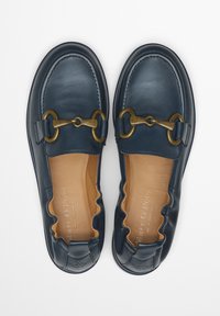 Marine leren instapschoenen met een goudkleurige kettingaccent, gegolfde details langs de bovenkant en een gladde tan leren binnenzool.