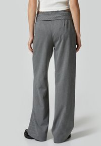 Grijs gestreepte wijde broek met een elastische tailleband en een gladde stof. Opvallende details zijn de verticale strepen en de relaxte pasvorm.