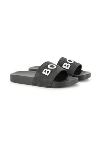 Fekete slip-on szandálok texturált talppal és széles pántokkal, amelyekre nagy fehér betűk vannak híva, amelyek a "BOSS" szót írják.