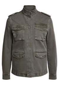 Chaqueta militar de color caqui, hecha de un tejido resistente. Presenta un cuello alto, cierre de botones, dos bolsillos en el pecho y hombreras.