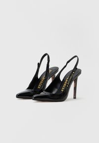 Décolleté in vernice nera con cinturino alla caviglia, punta appuntita e tacco a stiletto di 10 cm. Presentano un dettaglio con logo all'interno e un'accentuazione testurizzata sul tacco.