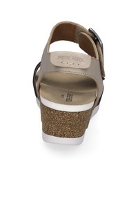 Sandale beige avec semelle en liège, brides en cuir, boucle réglable et semelle blanche. Texture lisse avec un logo subtil sur la semelle intérieure.