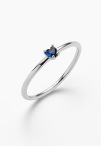 Silberring mit einem herzförmigen blauen Edelstein, der in einer Viergrifffassung platziert ist, und einem glatten, polierten Ringband.