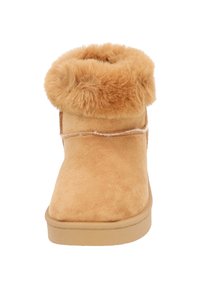 Tan suède enkellaarsjes met een fluffy bontkraag, ronde neus en platte zool. De schacht heeft stiksels langs de zijkant.