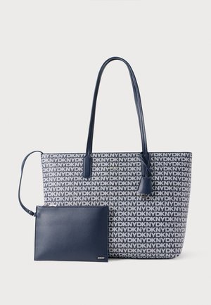 Toteveske i blått og hvitt logomønster med lange håndtak; inkluderer en matchende marineblå pouch med glidelås. Glatt tekstur og strukturert form.