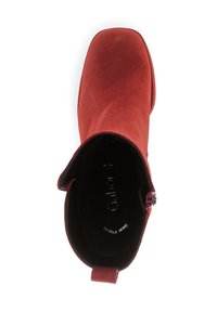 Red suede ankle boot with a square toe, side zipper, and a soft texture. Inside features embossed branding on a black insole.