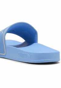 Blå skiftesandal med en tekstureret overdel, åben tå-design og flad sål. Har et logo og kontrastkanter langs siden.