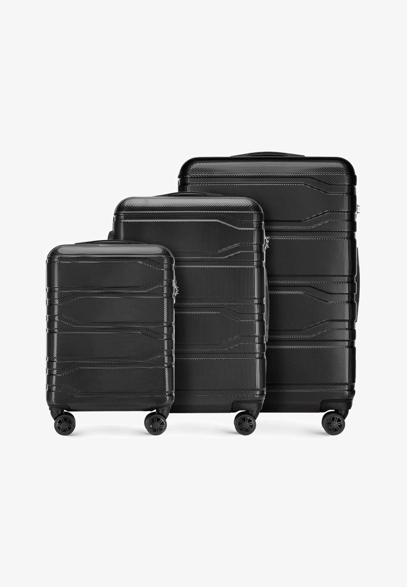 Set di tre valigie nere rigide di diverse dimensioni. Superficie testurizzata con linee orizzontali, dotate di quattro ruote ciascuna per la mobilità.