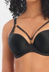 Zwarte bh met gladde, gevoerde cups. Bevat gouden hardware accenten en contrasterende bandjes, inclusief een decoratief ontwerp over de borst.
