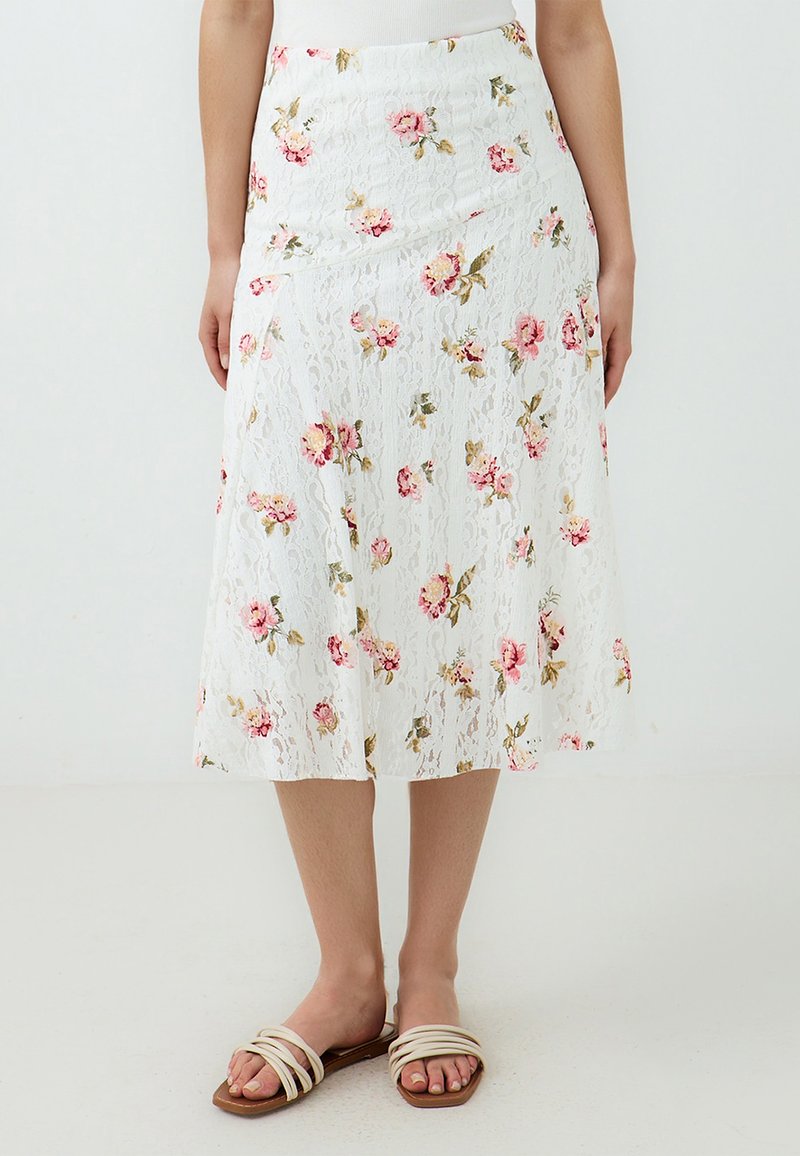 Weiße Spitzen-Midi-Rock mit rosa Blumenmustern, ausgestattet mit einer taillierten Taille und fließender Silhouette. Kombiniert mit hellen, geschnallten Sandalen.