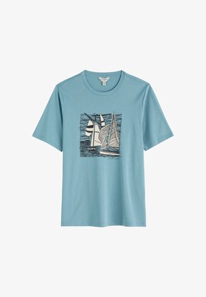 Camiseta de manga corta y cuello redondo en azul claro con un gráfico en blanco y negro de tres veleros sobre el agua en el centro.