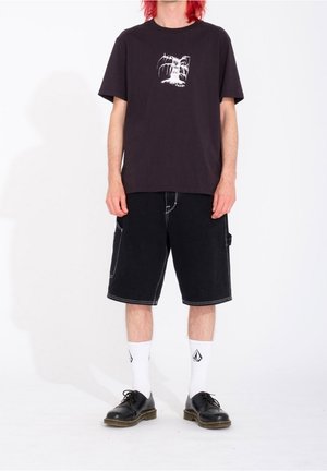 Zwarte katoenen t-shirt met witte grafische print, gecombineerd met zwarte denim shorts, witte sokken en zwarte schoenen. Eenvoudig, casual ontwerp.