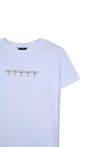 T-shirt bianco in cotone a maniche corte con un design decorativo a farfalla in strass argentati sul petto. Texture liscia.