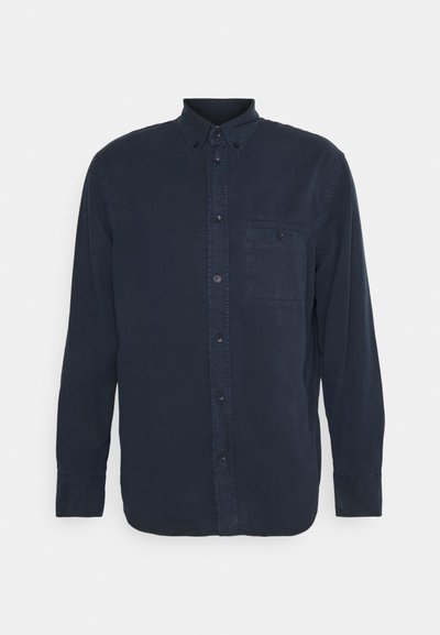 Camisa de botones de manga larga azul marina con un cuello, un bolsillo en el pecho y detalles cosidos a lo largo de la tapeta y las mangas.