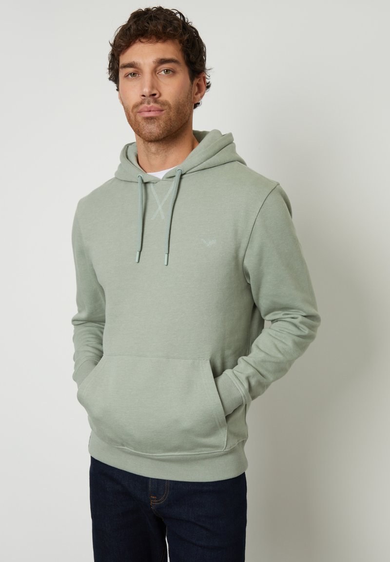 Lichtgroene hoodie gemaakt van een katoenmix, met een kangoeroezak, een verstelbare capuchon en ribgebreide manchetten. Draagt met donkere jeans.