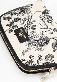 Zwarte bloemenbedrukte portefeuille met een crèmekleurig body van stof, zwarte leren accenten, gouden rits en een zwart logo patch.