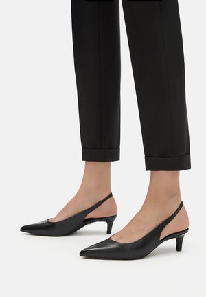 Černé kožené sandály na podpatku s špičatou špičkou a nízkým jehlovým podpatkem, které mají výřezový design po stranách a hladký povrch.