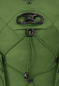 Le tissu texturé vert du sac à dos est doté de matériel noir et de cordons élastiques. Il comprend un système de sangle centrale pour une fermeture sécurisée.