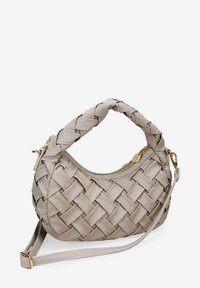 Bolso de mano tejido en cuero beige claro con un asa trenzada, cremallera dorada y correa para el hombro desmontable. Superficie texturizada con un acabado suave.