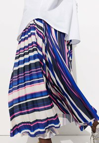 Jupe plissée avec de grandes rayures verticales en bleu, rose et blanc ; tissu léger au toucher doux ; mise en valeur par une silhouette fluide.