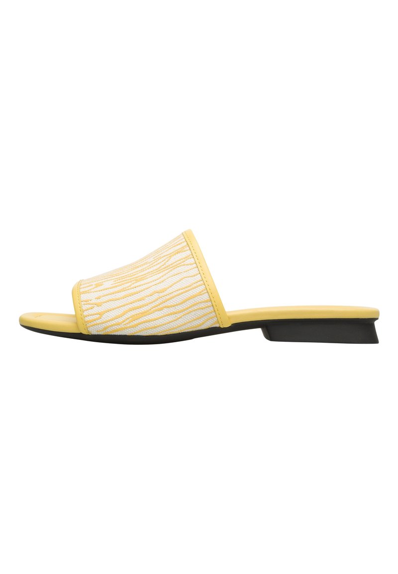 Yellow slip-on sandal with a textured white strap featuring a linear pattern, low black heel, and smooth matte finish.