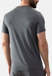 Harmaa lyhythihainen t-paita, joka on valmistettu sileästä puuvillasekoitekankaasta. Paidassa on pyöreä kaula-aukko ja yksinkertainen muotoilu ilman lisäkuvioita tai -koristeita.